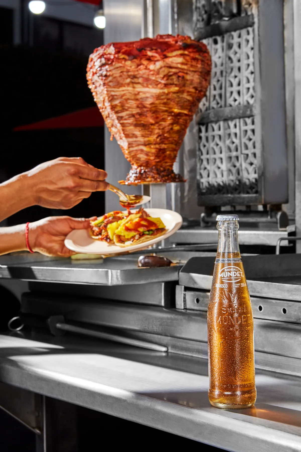Sidral Mundet — producto en escena de taquería, montaje de tacos al pastor