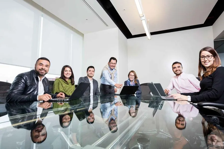 Retrato corporativo — equipo directivo alrededor de mesa de juntas